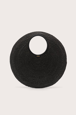 An oversized black woven circular handbag on a light beige background