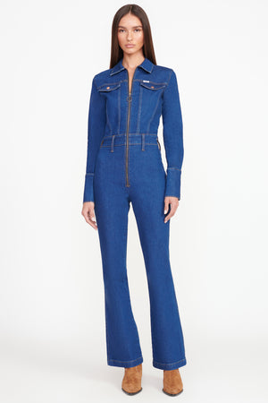 Full body shot of model in the dark rinse long sleeve jumpsuit,