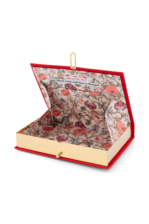 An open book clutch with a red velvet-like cover, gold-tone hardware, and a floral-patterned interior on a white background.