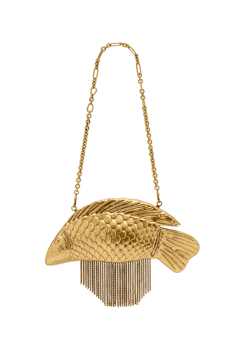 A gold fish-shaped shoulder bag with a textured scale pattern and dangling fringe, suspended from a delicate gold chain strap against a plain white background.