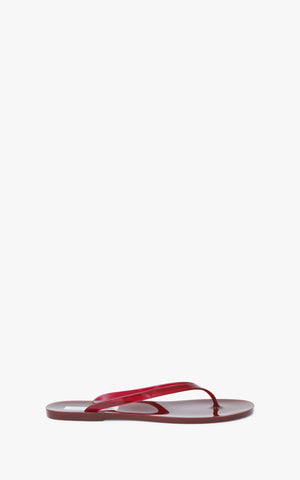 Red jelly flip flop sandal on a white background