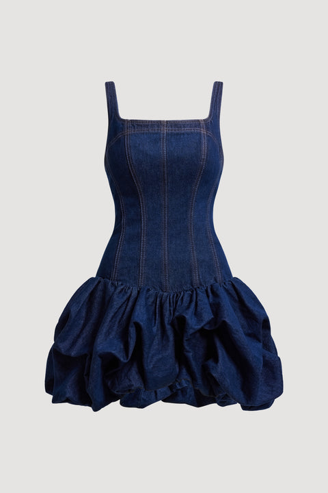 Flat lay of navy blue denim mini dress with ruffled skirt on a white background