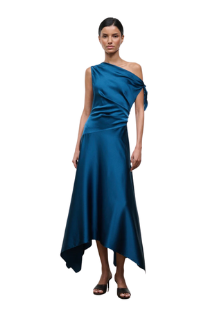 A woman modeling a midi-length, one-shoulder satin dress in a rich teal blue color, set against a plain white background.