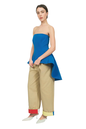 A woman wearing a strapless cobalt blue structured top with a peplum bodice