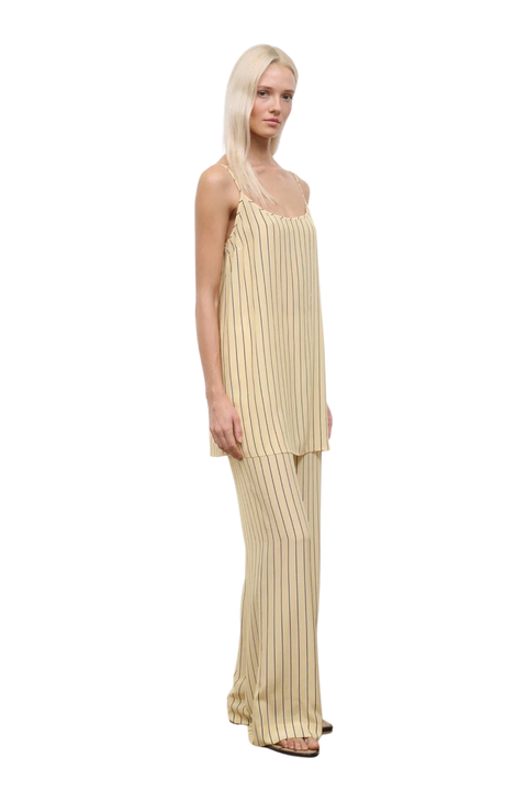 Woman wearing a yellow striped two piece pants and sleeveless top set on a white background side angle