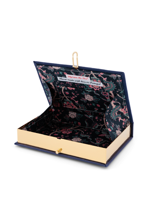 An open book clutch with a navy blue velvet cover, gold-tone clasp, and a dark floral-patterned interior lined with matching navy velvet.