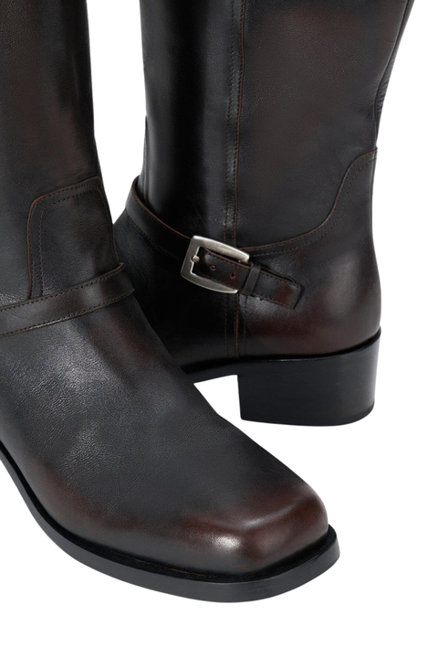 Pair of dark brown leather boots with a buckle on a white background