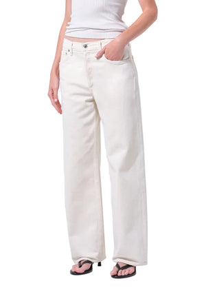 Person wearing white wide-leg, mid-rise jeans and a white top on a white background from the front