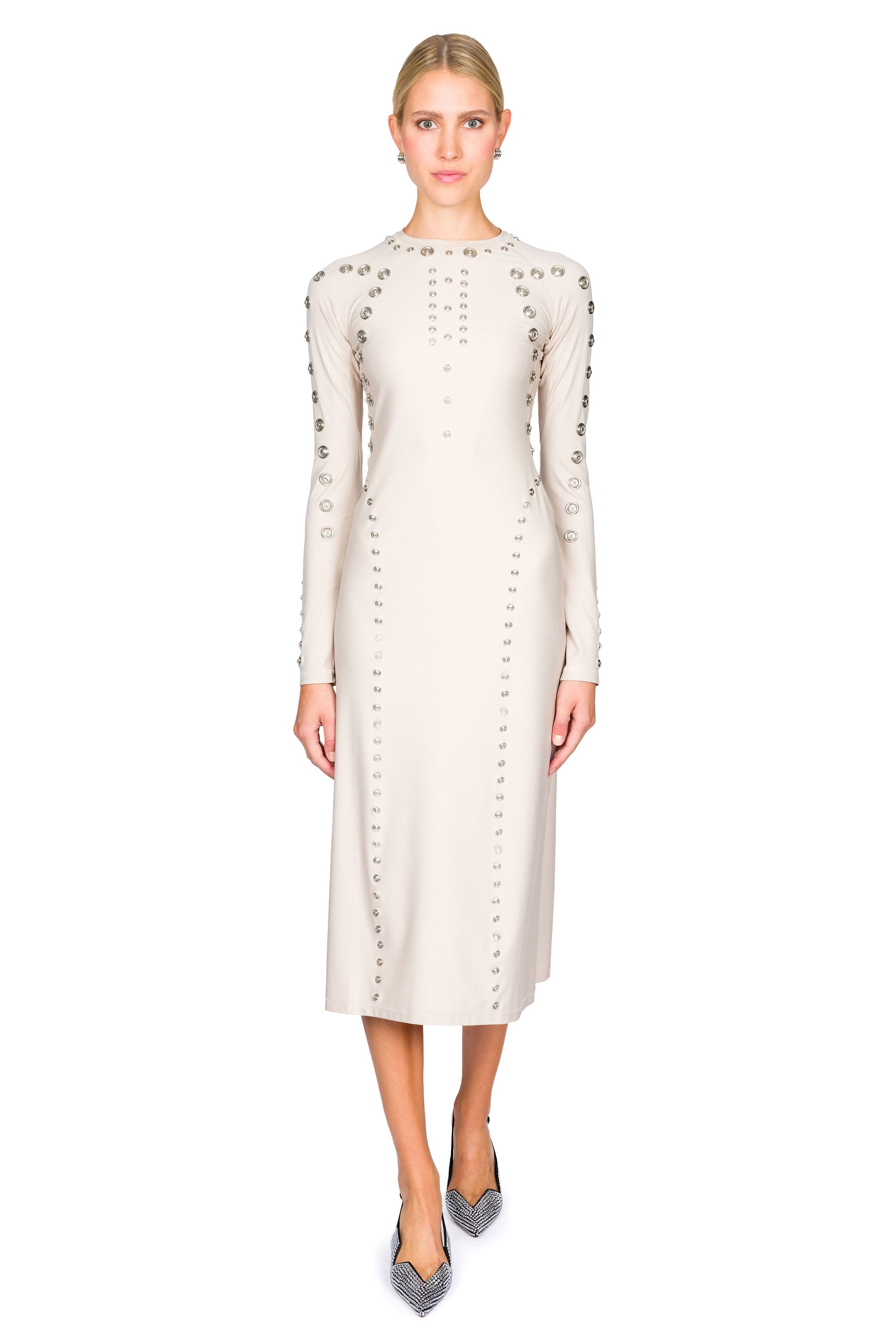 Woman posing in a long-sleeve dress beige midi dress with decorative snaps on a white background