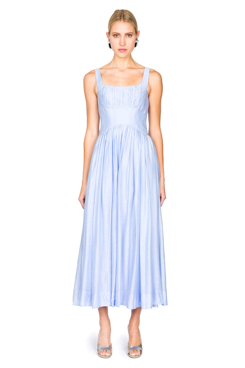 Woman wearing a light blue maxi dress on a white background