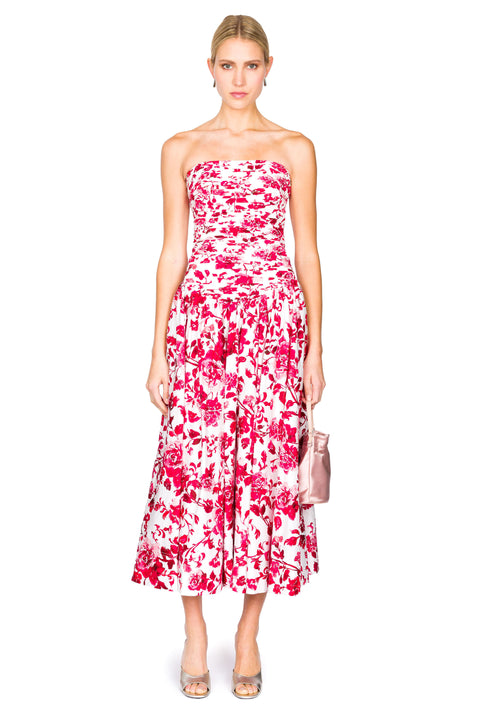 Woman wearing a strapless floral maxi dress on a white background