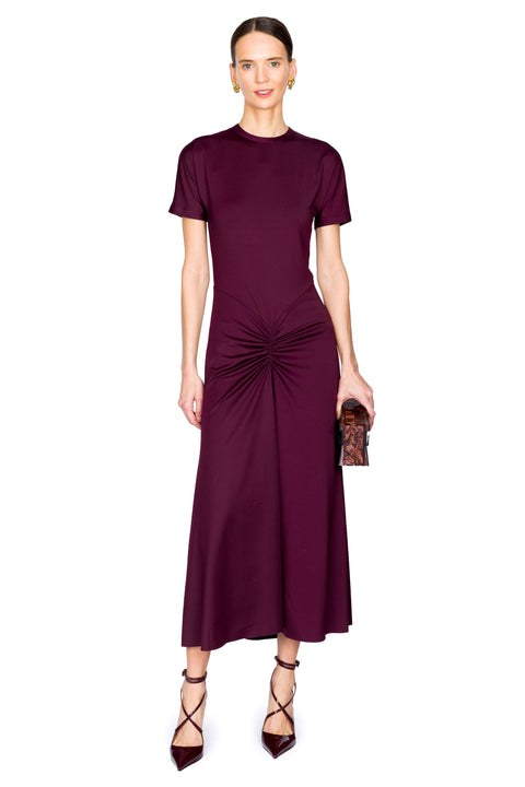 Woman wearing a burgundy midi dress with a scrunch detail on a white background