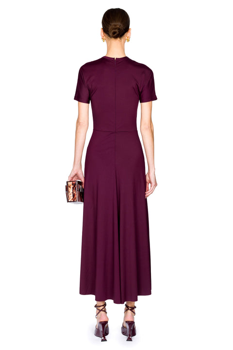 Woman showing back of satin burgundy midi dress on a plain white background