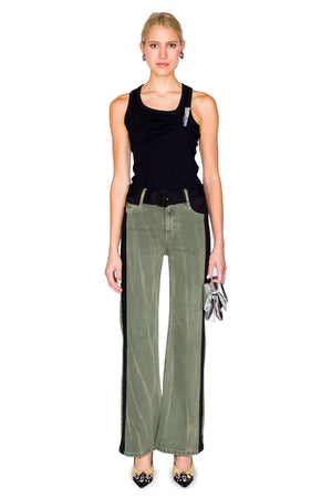 Woman wears straight leg jeans with black velvet belt and stripes down the side with black tank top.