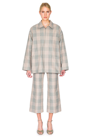 Woman wears oversized blue and grey checked jacket with matching pants.