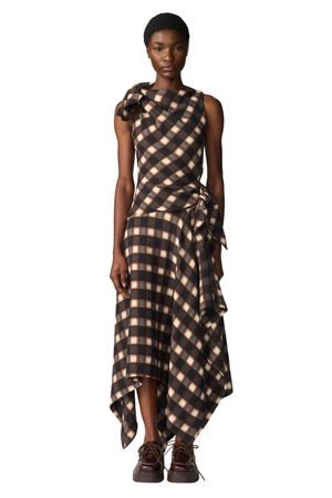 A model wearing a sleeveless, high-low dress with a diagonal checkered pattern in brown and beige, paired with dark brown lace-up shoes, against a plain white background.