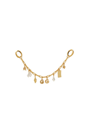 Gold bag chain with various charms on a light beige background