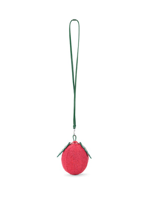 Ghost image of a beaded tomato bag with a green crossbody strap.
