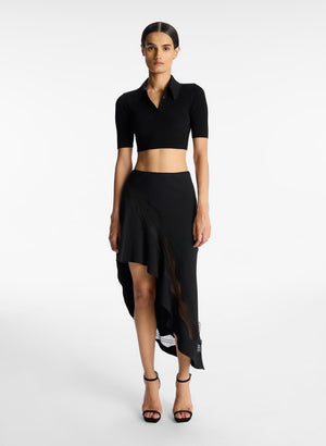 Model facing the camera in the black cropped collared top
