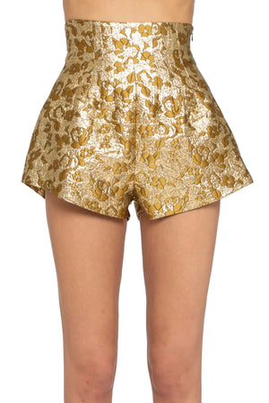 Gold metallic shorts worn by a person on a white background