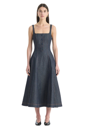 Woman wearing a dark denim midi dress on a white background