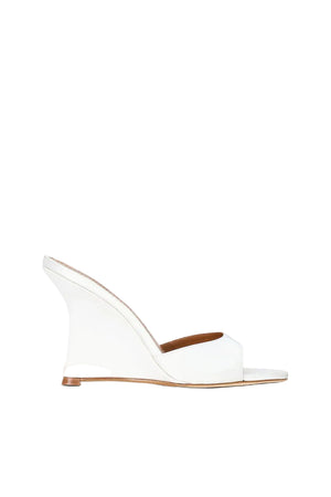 White wedge sandal with a brown insole on a white background