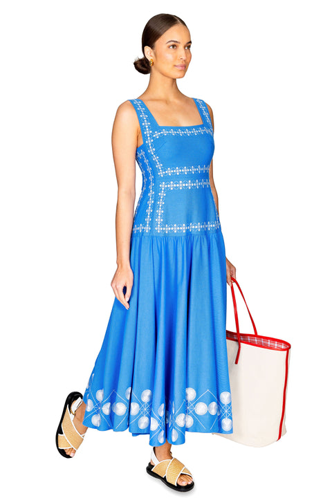 Model walking to the right showing the side of the blue cotton midi dress.