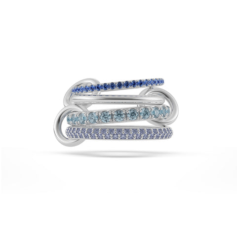 Ghost image of a Spinelli Kilcollin Iris ring that features one 1.7mm sterling silver band pave with blue sapphires, one 2.3mm sterling silver band, one 2.8mm sterling silver band pave with aquamarine, and one 2.8mm sterling silver band pave with tanzanite, all connected by three sterling silver connectors.