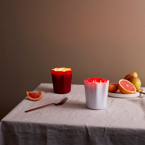 Red and white murano glass candles set on a tablescape with grapefruit.