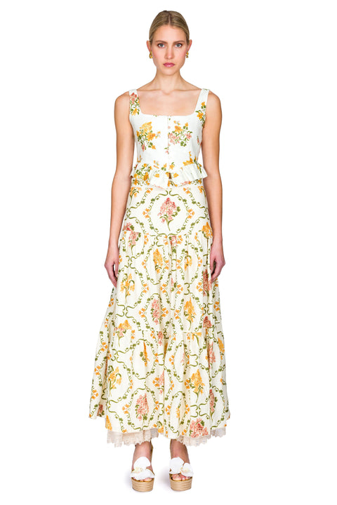 Woman wearing a yellow and pink floral cropped tank and maxi skirt on a white background facing forward
