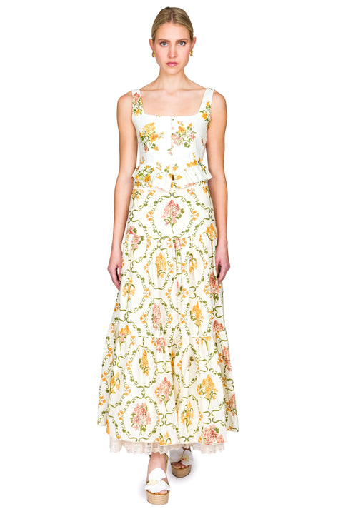 Woman wearing a yellow and pink floral cropped tank and maxi skirt on a white background from the front