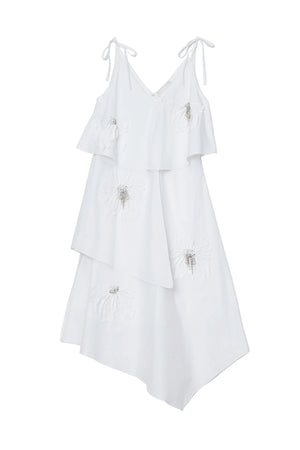 White layered dress with floral embellishments on a white background