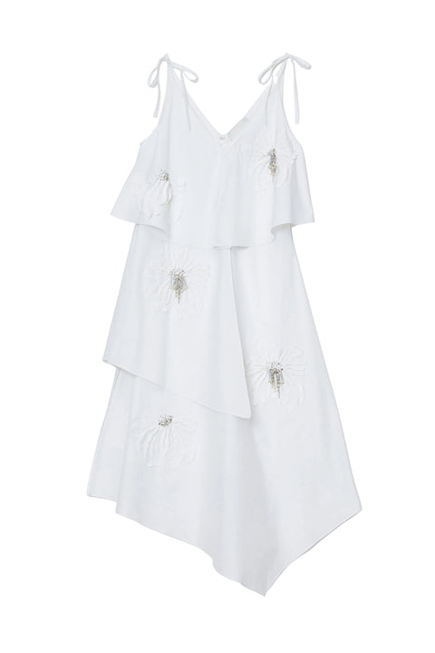 White layered dress with floral embellishments on a white background