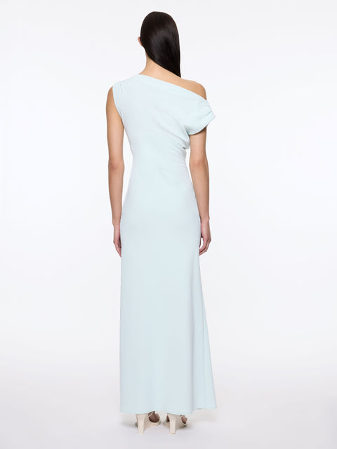Back of woman wearing a light blue maxi off-shoulder dress on a white background