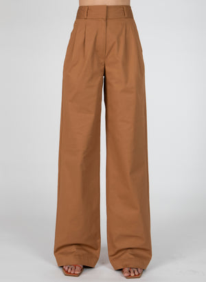 Up close of model from the waist down in the baxter wide leg pleated pants in brown.