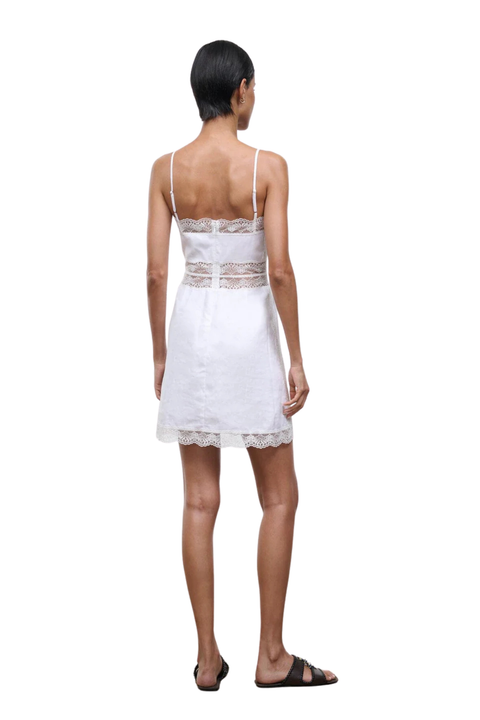 Woman wearing a white lace dress on a white background back angle