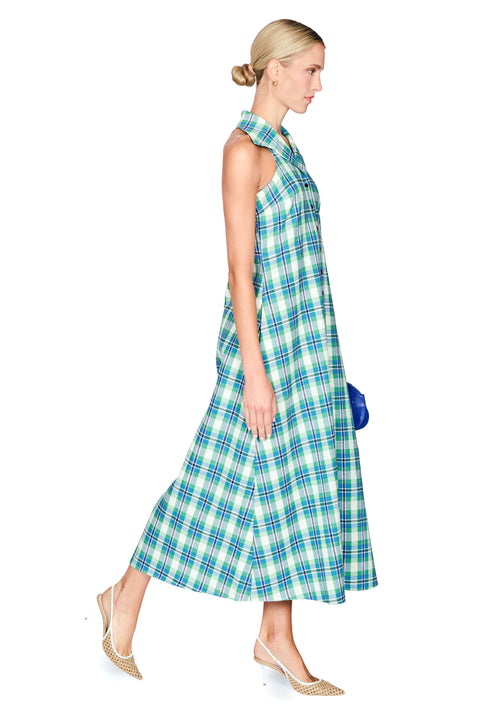 Woman wearing a blue and green plaid dress on a white background side angle