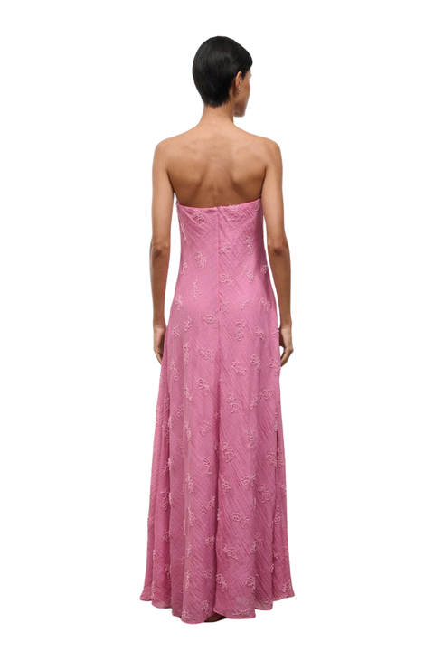 A woman wearing a strapless pink maxi dress with beaded embellishments back angle