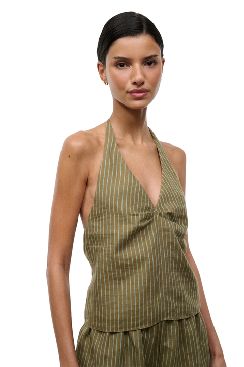 Woman wearing a green striped halter top and shorts set on a white background close up