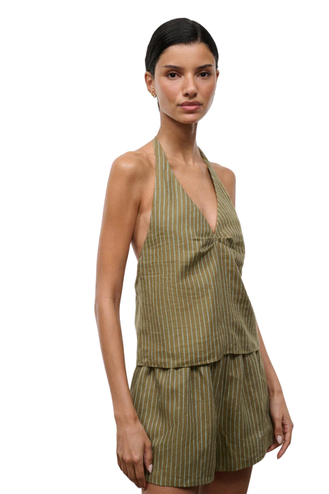 Woman wearing a green striped halter top and shorts set on a white background side angle