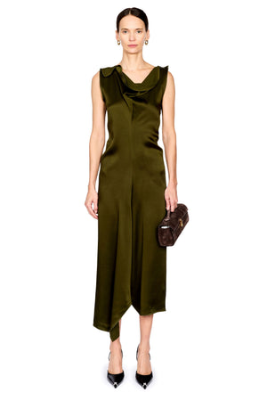 A model wearing a sleeveless olive green satin midi dress with a draped cowl neckline, holding a small brown clutch purse, set against a plain white background.