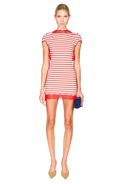 A model wearing a red and white striped mini dress with red lace trim, holding a small blue clutch, on a solid white background.