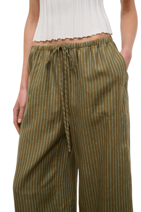 Woman wearing green striped linen pants with a drawstring on a white background close-up