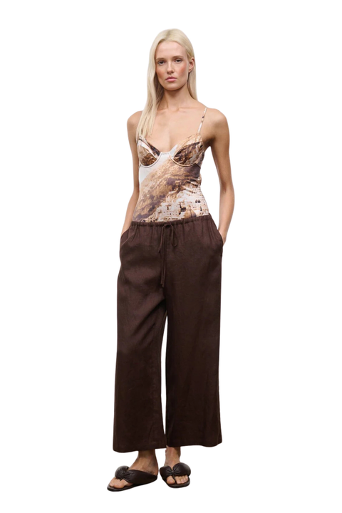 Woman wearing brown wide-leg pants on a white background