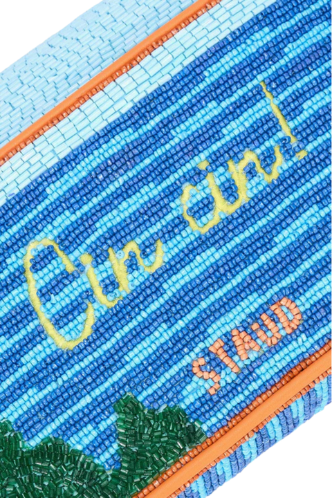 A close-up of the words 'cin cin!' on a beaded handbag