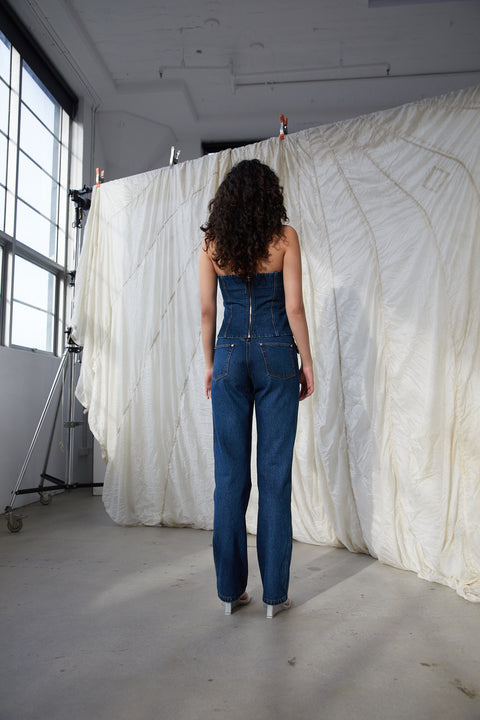 Model facing away showing the back of the jo denim bodice with zipper closure.