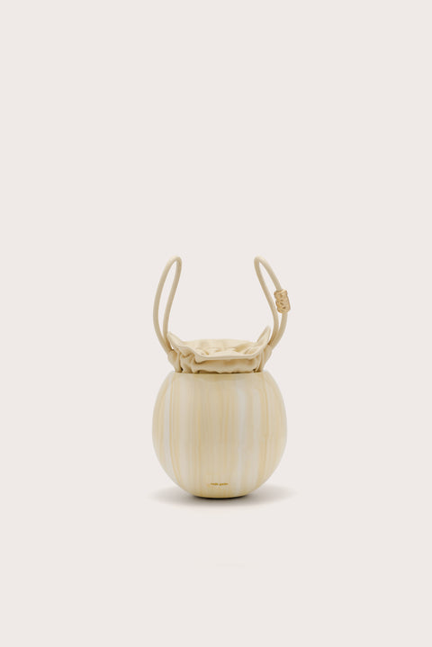 A spherical handbag made of marbles yellow acrylic with an inner pouch that sinches closed and two matching handles. 
