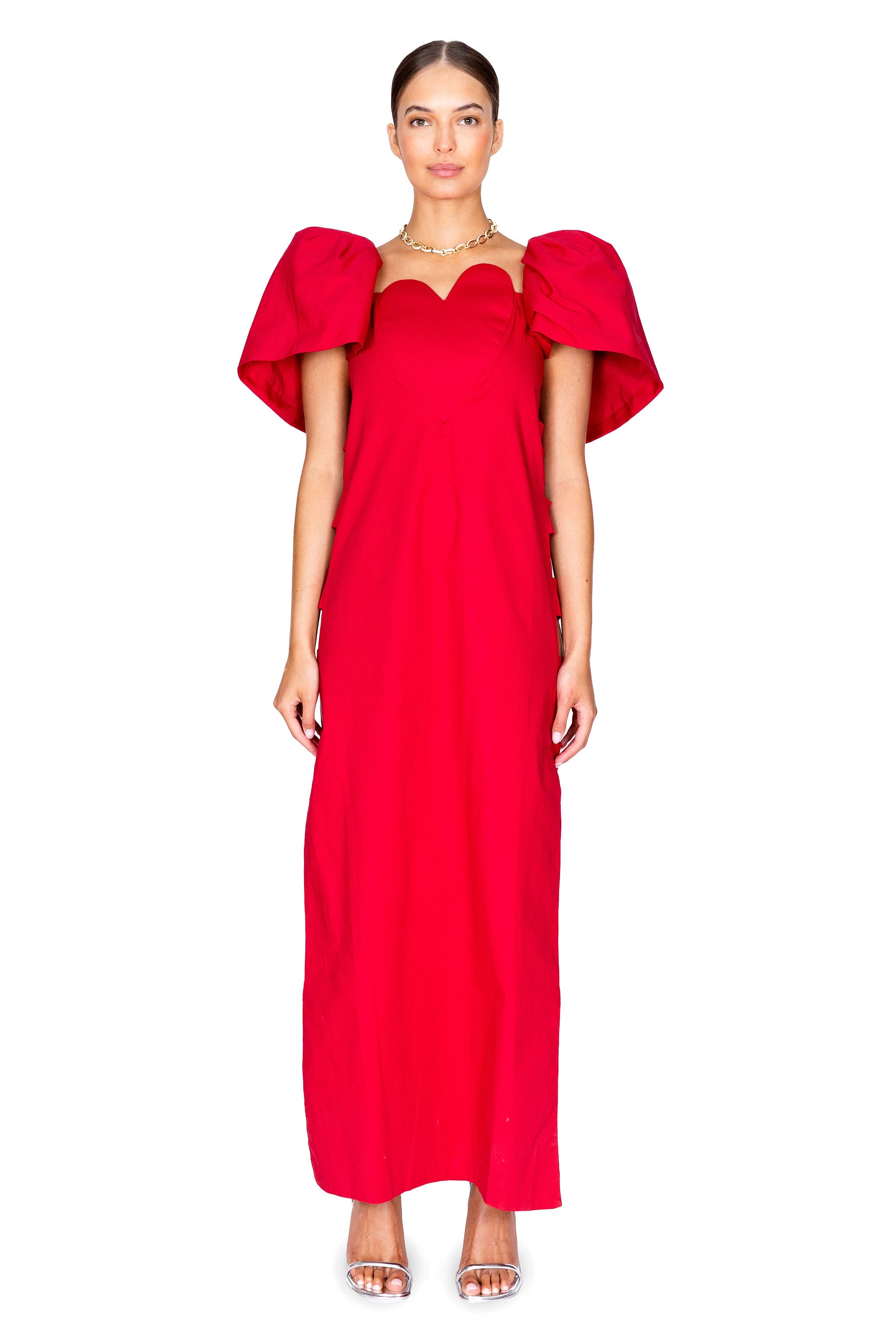 Model facing camera in the solid heart open-side long dress in red.