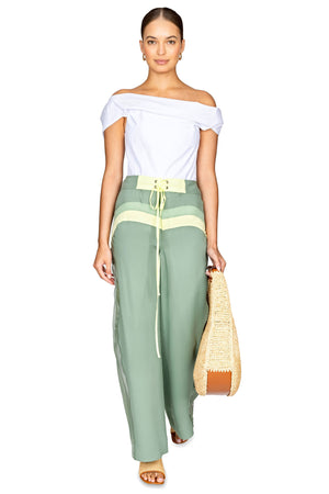 Model walking forward wearing the light green side panel surf pant with waist tie.