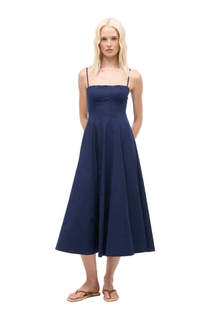 Woman wearing a navy blue midi dress on a white background